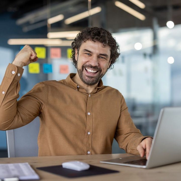 Ingenieur arbeitet am Laptop und freut sich